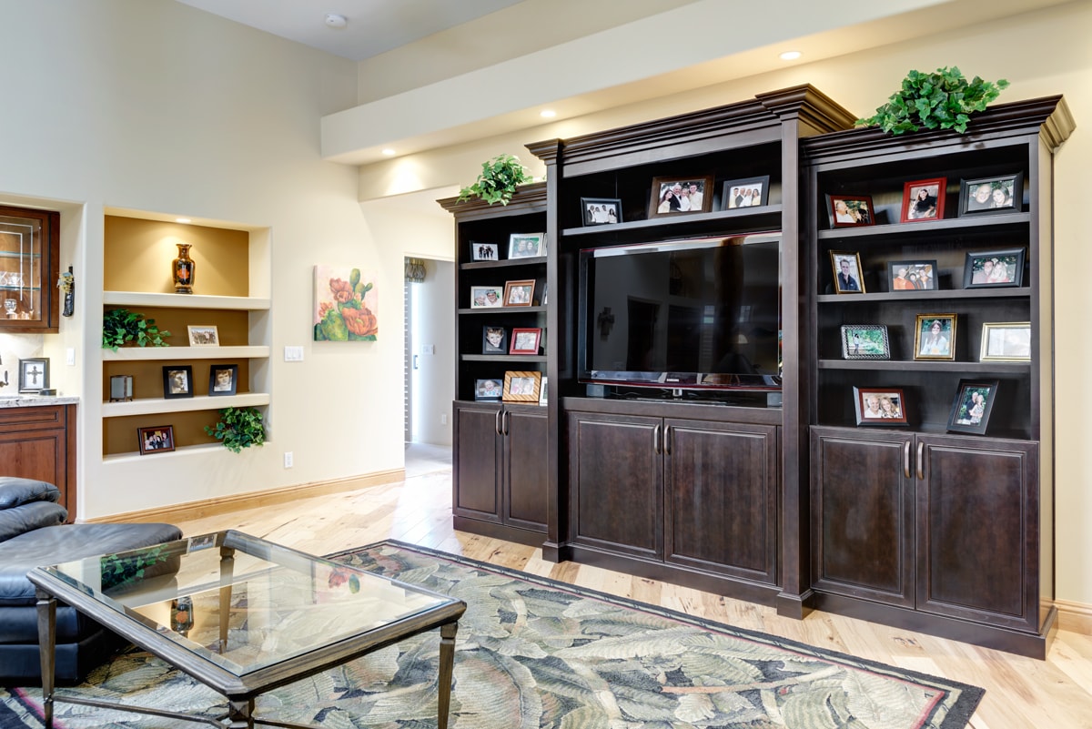 Large wooden media unit with shelves displaying photos.