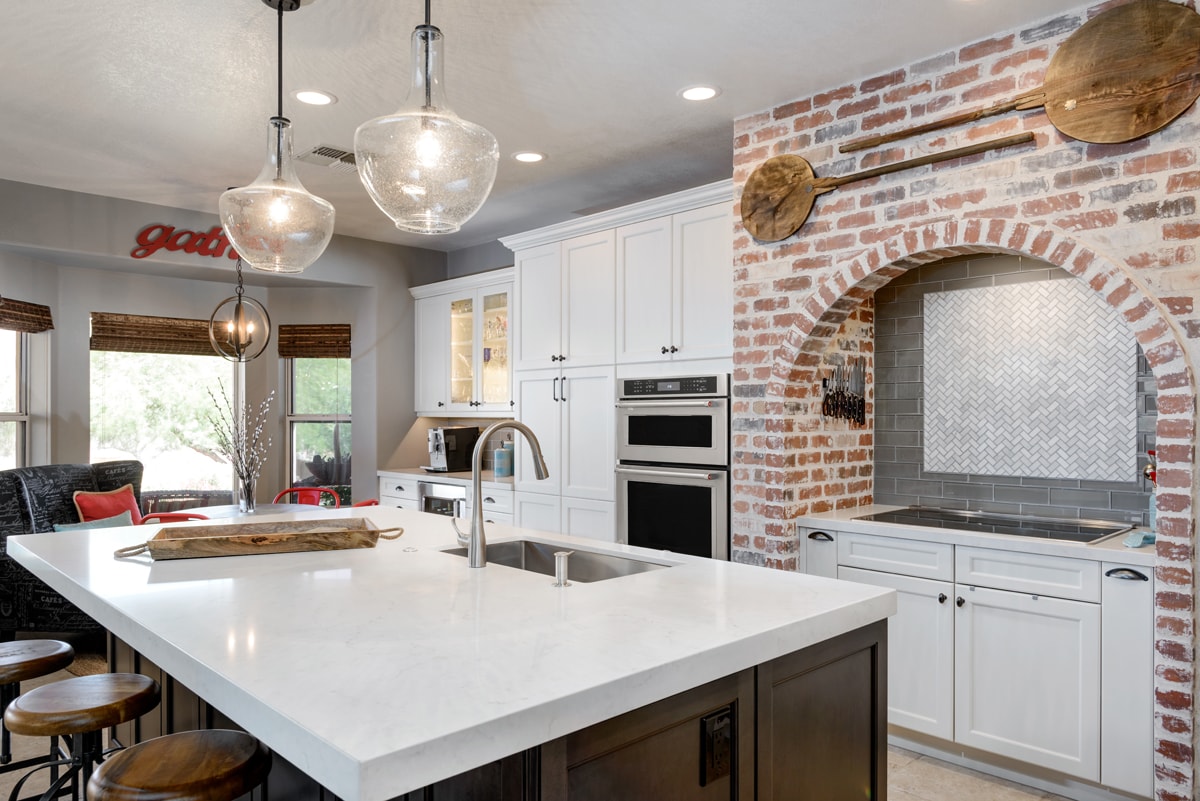 Kitchen with a large brick arch and island with bar seating.