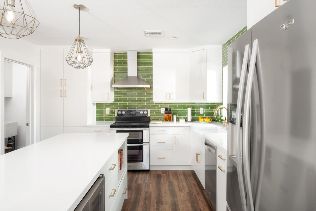 White kitchen cabinets with a white island.