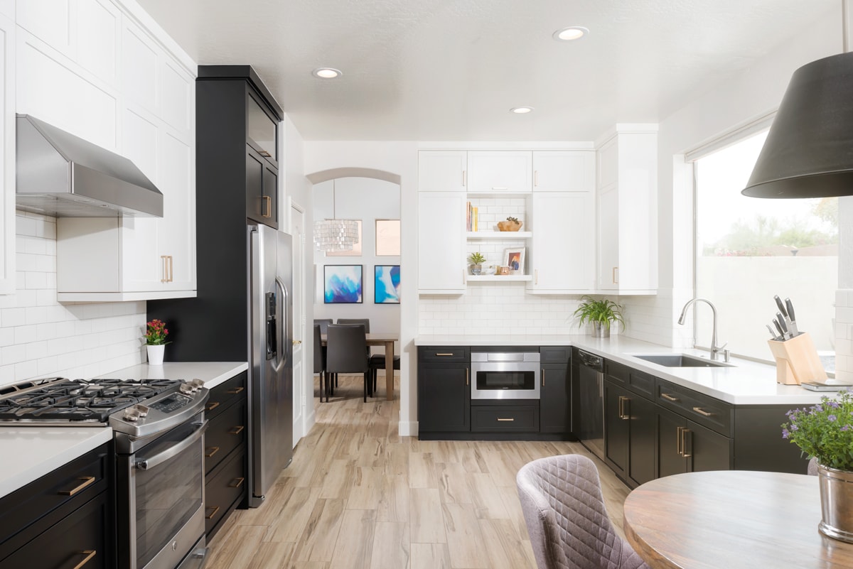 Modern black and white kitchen looking through a tall white archway.