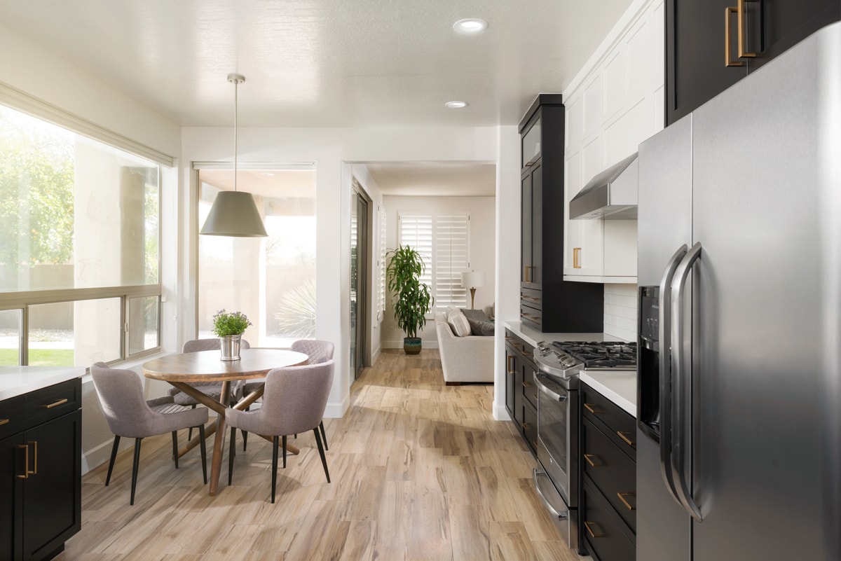 A black and white kitchen looking towards a dining table.