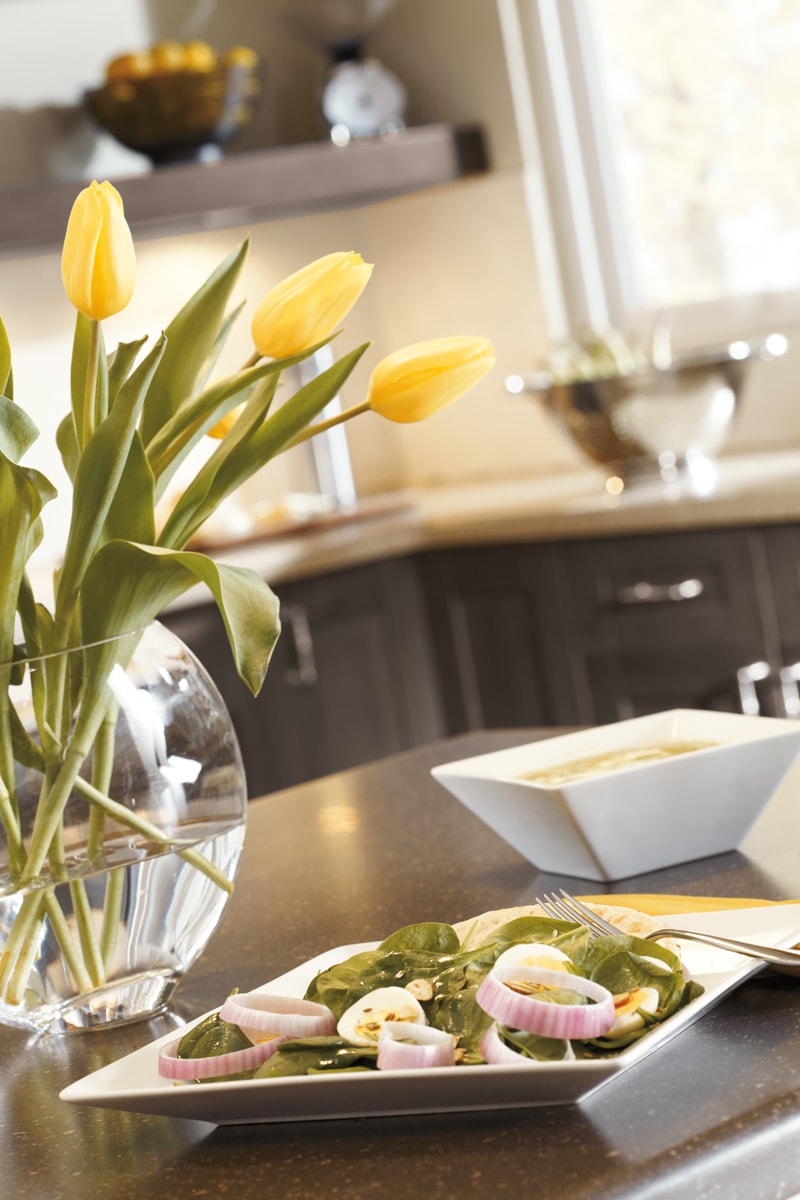 Close-up of a salad on a plate on a brown kitchen island.