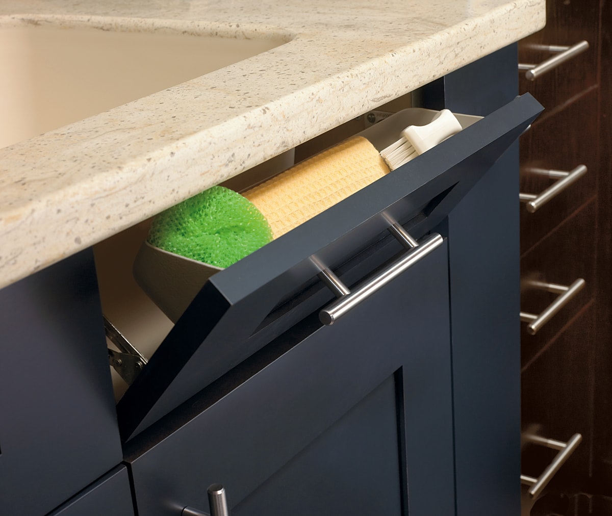 Navy blue cabinetry with a tray storing a sponge.