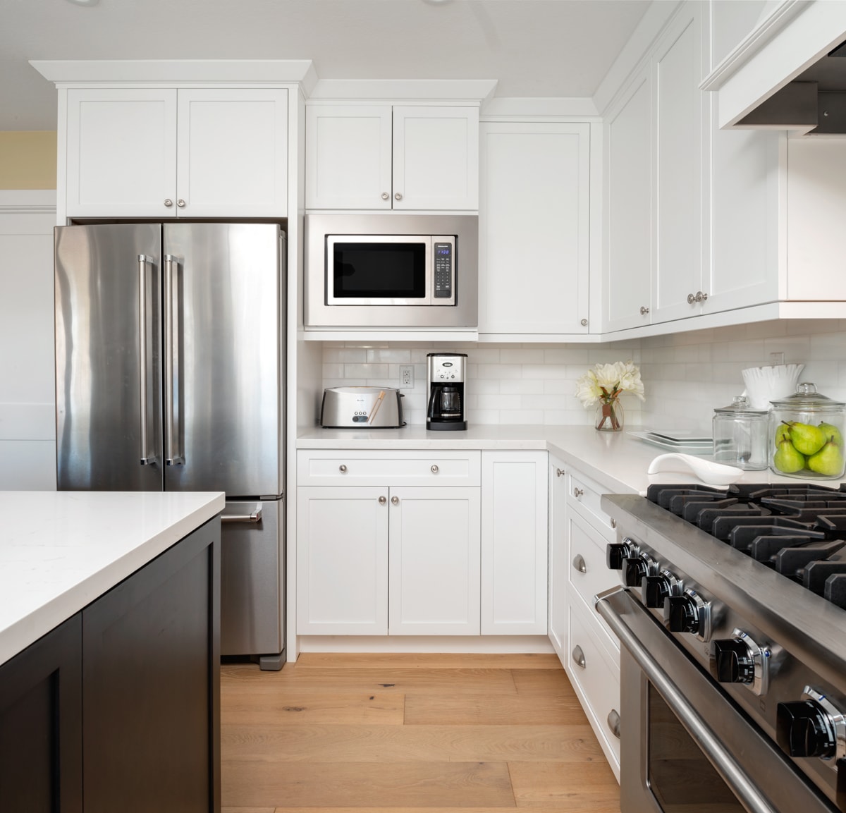 Corner of a white kitchen with shaker-style cabinets.