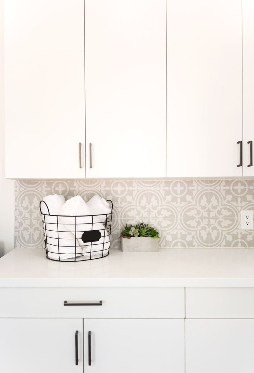 Close-up shot of white slab-paneled cabinets with black hardware pulls.