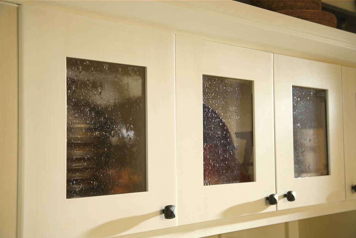 Cream cabinets with glass door inserts.